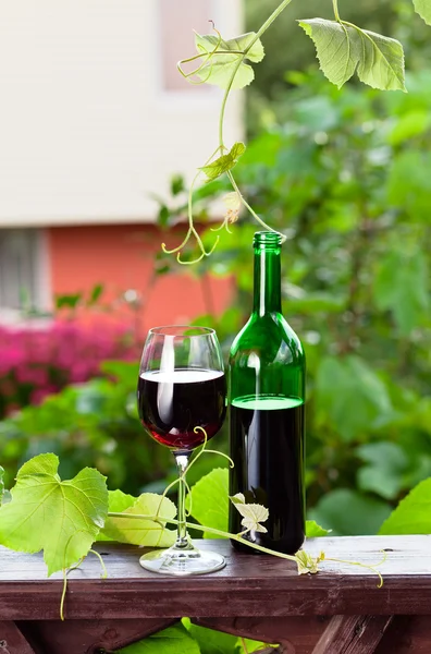 Bottle and glass with red wine — Stock Photo, Image