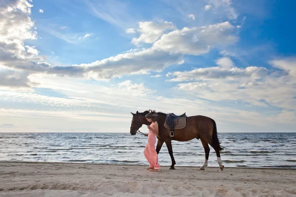 Красивая девушка с лошадью на берегу моря — стоковое фото
