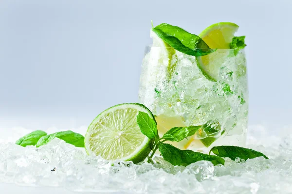 Trozos de lima y hojas de menta con hielo — Foto de Stock