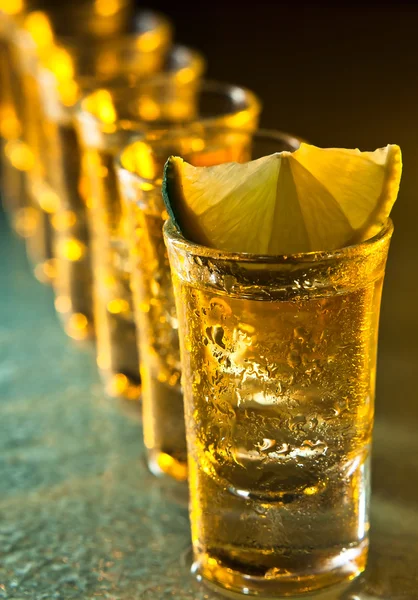 Tequila en kalk op glazen tafel — Stockfoto