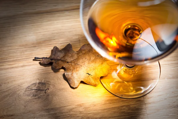 Brandy en gedroogde eiken bladeren — Stockfoto