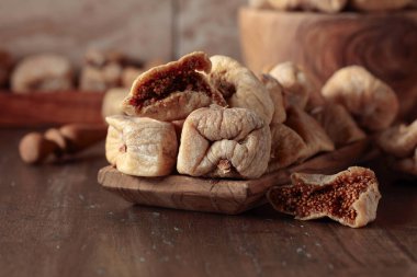 Eski mutfak masasındaki ahşap bir tabakta kurutulmuş incir..