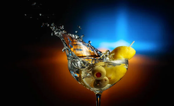 Klasické Martini Zelenými Olivami Citrónem Cáká Tmavém Pozadí Barevným Podsvícením — Stock fotografie
