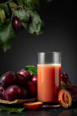 Taze mor erikli bir masada bir bardak erik suyu..