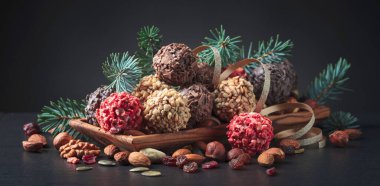 Ev yapımı çikolatalı, fındıklı, kurutulmuş meyveli, siyah bir masada..