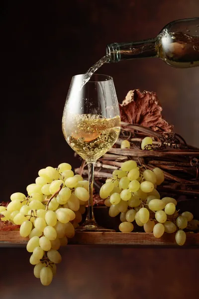 ワインをグラスに注ぐ 白ワインとブドウの束ヴィンテージ木製テーブル — ストック写真