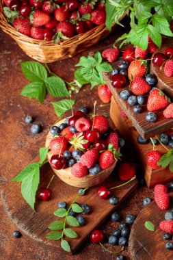 Yapraklı taze böğürtlen. Eski bir masada çilek, ahududu, yabanmersini ve tatlı kirazlar.. 