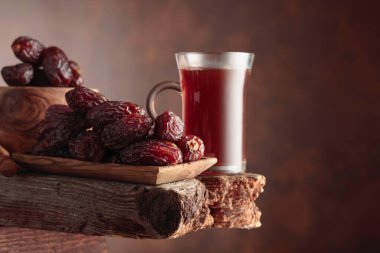 Çay ve kurutulmuş hurma eski ahşap bir masada..