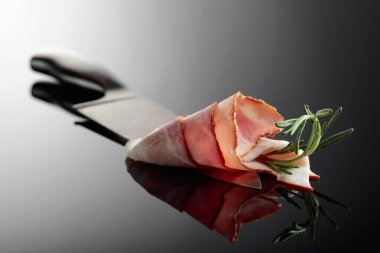 Mutfak bıçağında biberiyeli pastırma. Yansıtıcı arkaplan.