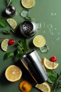 Kokteyl yapmak için malzemelerle karıştırıcı. Yeşil arka plan. Üst görünüm.