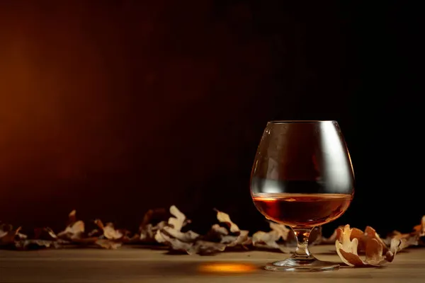 Snuif Cognac Een Oude Eiken Tafel Met Opgedroogde Eikenbladeren Kopieerruimte — Stockfoto