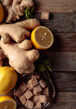Zencefilli çay için malzemeler. Zencefil, limon, nane ve esmer şeker eski ahşap bir masada..