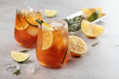 Limonlu buzlu çay, limon ve biberiye dallarıyla süslenmiş buz. Turunçgil dilimli donmuş bardaklar..