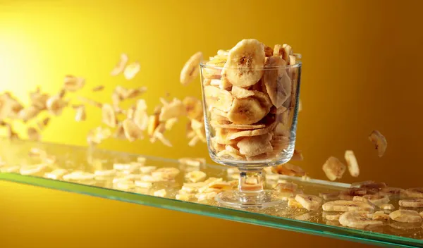 Las Patatas Fritas Plátano Caen Recipiente Vidrio Fondo Amarillo Con — Foto de Stock