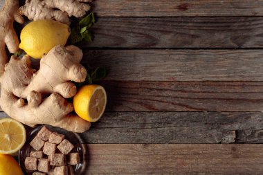 Zencefilli çay için malzemeler. Zencefil, limon, nane ve esmer şeker eski ahşap bir masada..