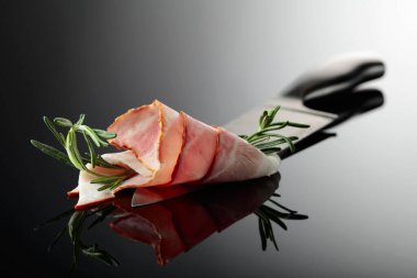 Mutfak bıçağında biberiyeli pastırma. Yansıtıcı arkaplan.