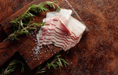 Pastırma, biberiye, tuz ve biber, eski bir kesme tahtasında. Üst görünüm.