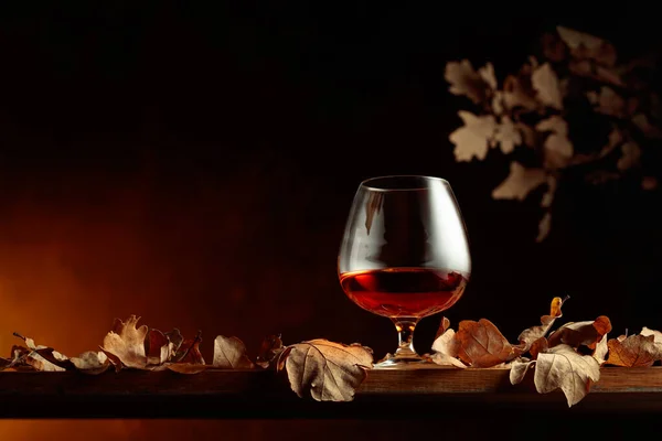 Snifter Brandy Sur Une Vieille Table Chêne Avec Des Feuilles — Photo