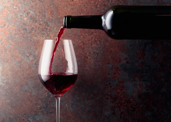 Rotwein Wird Aus Einer Flasche Ein Weinglas Auf Rostbraunem Hintergrund — Stockfoto