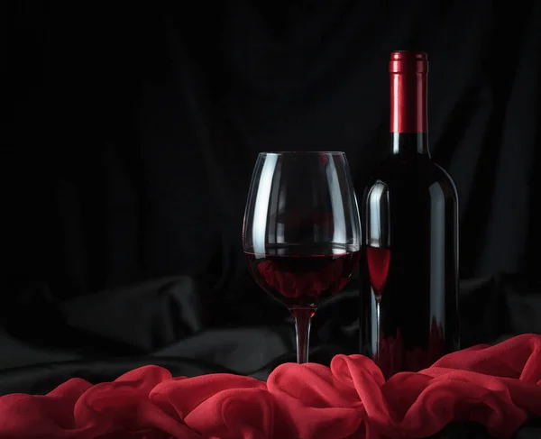 瓶子和杯子在黑色背景上的红酒 — 图库照片