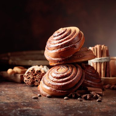 Tarçın tozu serpilmiş taze pişmiş tatlı çörekler. Boşluğu kopyala.