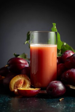 Taze mor erikli bir masada bir bardak erik suyu. Boşluğu kopyala.