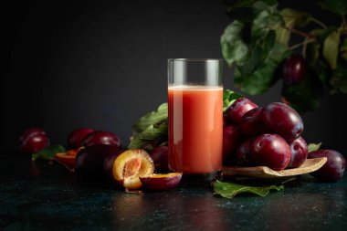 Taze mor erikli bir masada bir bardak erik suyu. Boşluğu kopyala.