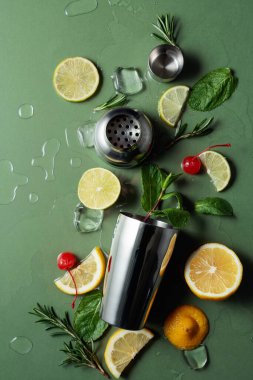 Kokteyl yapmak için malzemelerle karıştırıcı. Yeşil arka plan. Üst görünüm.