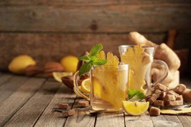 Malzemeli zencefil çayı. Zencefil, limon, nane ve esmer şeker eski ahşap bir masada.