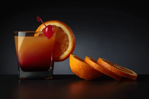 어두운 배경에 오렌지 주스와 오렌지 슬라이스 한잔을 — 스톡 사진