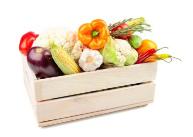 Beyaz arka planda izole edilmiş ahşap bir kutuda çeşitli taze sebzeler. Domates, paprika, karnabahar, kırmızı biber, sarımsak, patlıcan, salatalık, mısır ve biberiye sunuluyor.