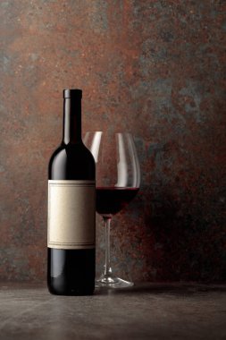 Paslı kahverengi arka planda eski boş etiketli bir şişe kırmızı şarap. Boşluğu kopyala.