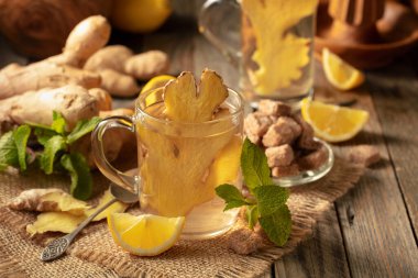 Malzemeli zencefil çayı. Zencefil, limon, nane ve esmer şeker eski ahşap bir masada.
