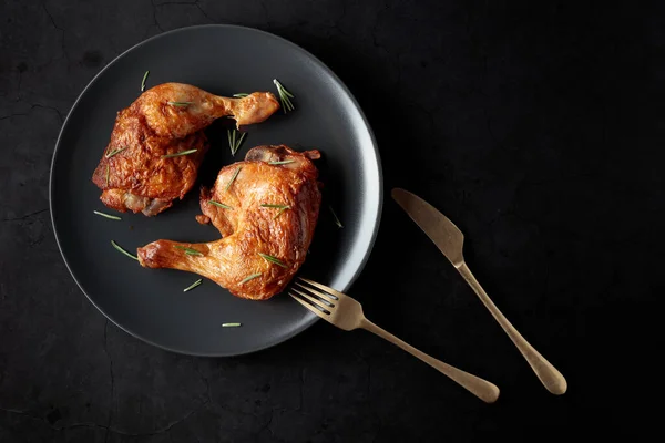鶏の脚を焼き黒皿の上にローズマリーを振りかけた コピースペース付きのトップビュー — ストック写真
