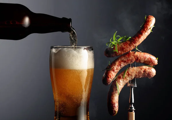 啤酒和烤巴伐利亚香肠与迷迭香 叉子上撒满迷迭香的香肠 — 图库照片