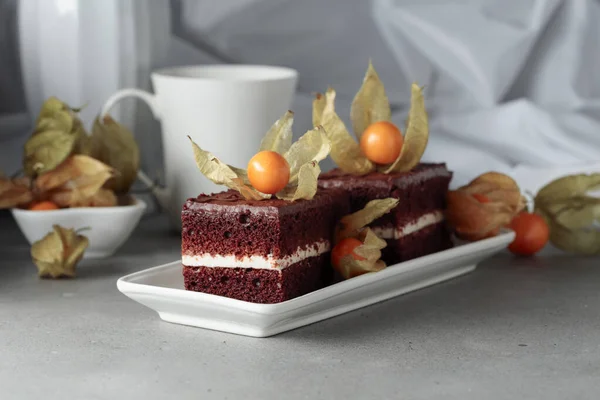 灰色のテーブルの上に物理的に飾られたチョコレートケーキ — ストック写真