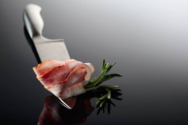 Mutfak bıçağında biberiyeli pastırma. Yansıtıcı arkaplan.