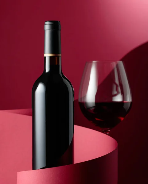 Flasche Rotwein Auf Rotem Hintergrund — Stockfoto