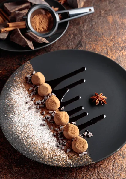 Čokoládové Lanýže Černém Talíři Čokoládovou Omáčkou Sladkosti Sypou Kakaovým Práškem — Stock fotografie