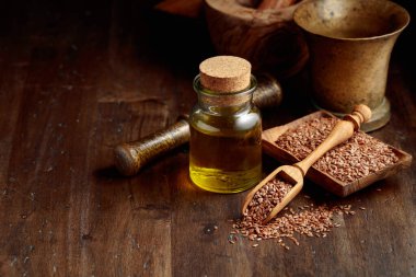 Keten tohumu ve keten tohumu yağı. Eski ahşap bir masanın üzerinde mutfak gereçleri ile keten tohumu yağı. Boşluğu kopyala. 