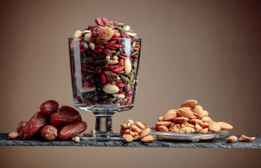 Kahverengi arka planda hurma ve kurutulmuş meyve, fındık ve tohumlar. Boşluğu kopyala.