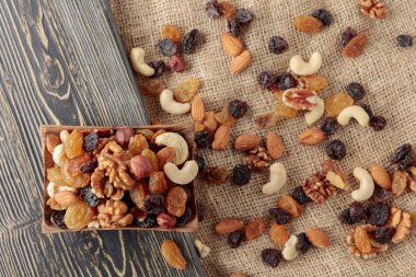 Kurutulmuş meyve ve fındık. Tahta bir masada fındık ve kuru üzüm karışımı. Kopyalama alanı olan üst görünüm.