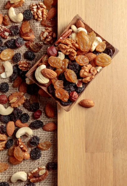 Kurutulmuş meyve ve fındık. Tahta bir masada fındık ve kuru üzüm karışımı. Kopyalama alanı olan üst görünüm.