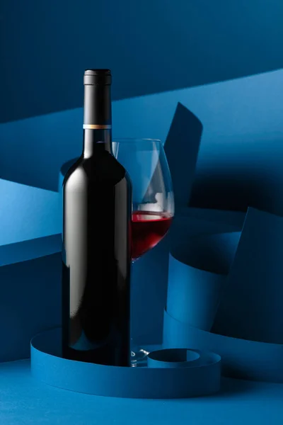 Flaska Och Glas Rött Vin Blå Bakgrund — Stockfoto