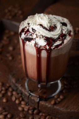 Kahverengi arka planda kremalı kahve ve çikolata kokteyli..