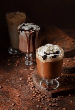 Kahverengi arka planda kremalı kahve ve çikolata içecekler..