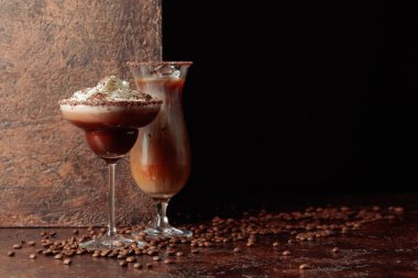 Kahverengi arka planda kremalı kahve ve çikolata içecekler. Boşluğu kopyala.