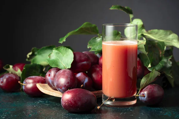Taze mor erikli bir masada bir bardak erik suyu. Boşluğu kopyala.