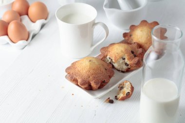 Mutfak masasında sütlü kekler. Beyaz ahşap bir masada ev yapımı üzümlü kek.. 