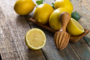 Eski ahşap bir masada limon ve sıkma.